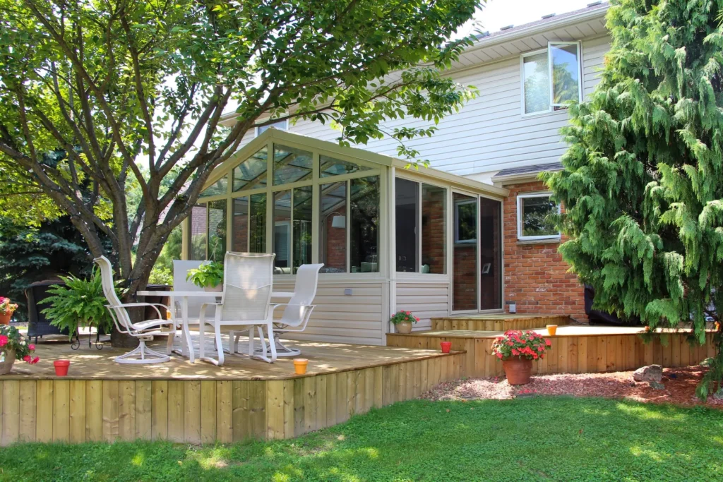 a patio with a glass wall and a tree